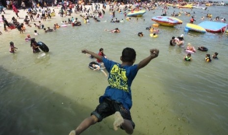 Ratusan pengunjung memadati pantai wisata Pulau Untung Jawa, Kepulauan Seribu, Jakarta, Kamis (31/7).