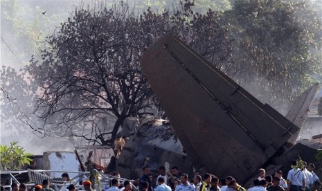  Ratusan petugas dan warga menyaksikan bangkai pesawat Fokker 27 yang jatuh di komplek perumahan Rajawali kawasan Lapangan Udara Halim Perdanakusuma, Jakarta, Kamis (21/6).