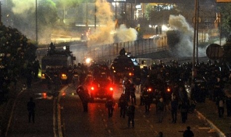 Ratusan petugas kepolisian berusaha menghalau para pengunjuk rasa di depan gedung DPR/MPR, Jakarta, Jumat (30/3). Demo menolak kenaikan BBM akhirnya berlangsung ricuh. 