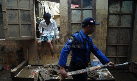  Petugas Sudin Pemadam Kebakaran Jakarta Timur membersihkan lumpur sisa banjir di pemukiman warga Kampung Pulo, Jatinegara, Jakarta, Kamis (13/2).  (Republika/Rakhmawaty La'lang)