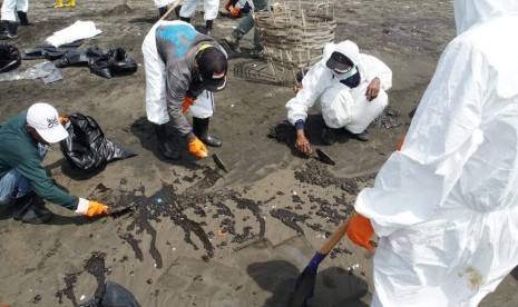 Ratusan warga di Desa Sedari, Kecamatam Cibuaya, Karawang, sedang membersihkan bibir Pantai Sedari dari tumpahan minyak mentah, Selasa (23/7). 