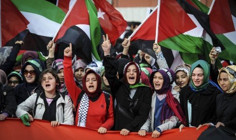 Ratusan warga mengibarkan bendera Turki dan Palestina saat pengadilan Turki melaksanakan sidang in absentia terhadap empat komandan militer Israel di Istanbul, Turki, Selasa (6/11). (foto : AP)