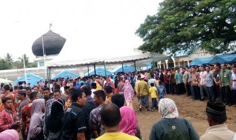 Ratusan warga menunggu kedatangan Presiden Jokowi di masjid At Taqarub, Trienggadeng, Pidie Jaya, Jumat (9/12). Tak sedikit dari mereka yang telah menunggu sejak subuh.