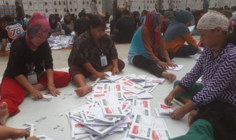 Ratusan warga tengah menyortir dan melipat surat suara pemilu 2019 di Gudang Logistik Komisi Pemilihan Umum (KPU) Kabupaten Bandung di Kampung Sawah, Soreang, Kabupaten Bandung, Kamis (14/3).