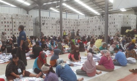 Ratusan warga tengah menyortir dan melipat surat suara pemilu 2019 di Gudang Logistik Komisi Pemilihan Umum (KPU) Kabupaten Bandung di Kampung Sawah, Soreang, Kabupaten Bandung, Kamis (14/3).