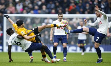 Raul Jimenez dari Wolverhampton Wanderers, berebut bola dengan Matt Doherty dari Tottenham, sama seperti Davinson Sanchez dari Tottenham, melakukan tekel kiri selama pertandingan sepak bola Liga Premier Inggris antara Tottenham Hotspur dan Wolverhampton Wanderers dan di White Hart Lane di London, Ahad (13/2/2022)..