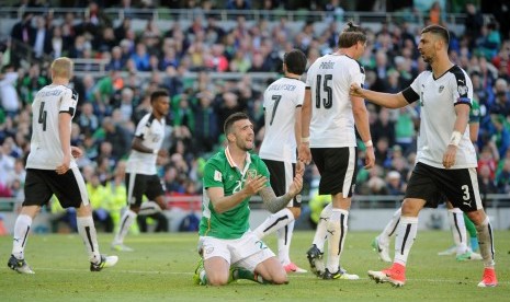 Reaksi pemain Republik Irlandia, Shane Duffy (tengah) di antara para pemain Austria pada laga kualifikasi Piala Dunia 2018 di Dublin, Ahad (11/6). Laga berakhir imbang 1-1.