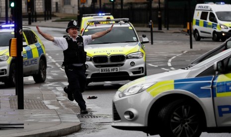 Reaksi seorang polisi London saat insiden penyerangan berlangsung di Jembatan Westminster, London.