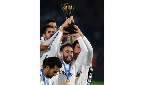 Real Madrid's Dani Carvajal lifts the trophy as his teammates celebrate after their victory in the final final match of the FIFA Club World Cup 2014 between San Lorenzo of Argentina and Real Madrid of Spain, in Marrakech, Morocco, 20 December 2014.