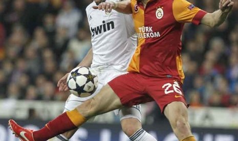 Real Madrid's Karim Benzema from France, left, challenfes Galatasaray's Semih Kaya, right, during the Champions League quarterfinal first leg soccer match between Real Madrid and Galatasaray at the Santiago Bernabeu stadium in Madrid, Wednesday, April 3, 2