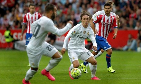 Real Madrid's Luka Modric (C) controls the ball during the Spanish Liga Primera Division soccer against Sporting Gijon match played at El Molinon stadium, in Gijon, northern Spain, 23 August 2015. 