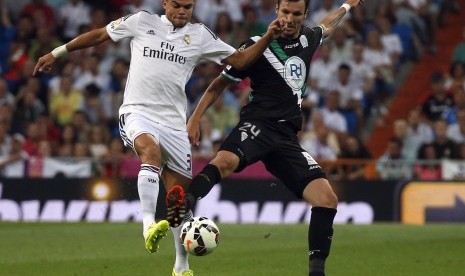 Real Madrid's Pepe (L) and Cordoba's Mike Havenaar challenge for the ball during their Spanish first division soccer match at Santiago Bernabeu stadium in Madrid August 25, 2014.