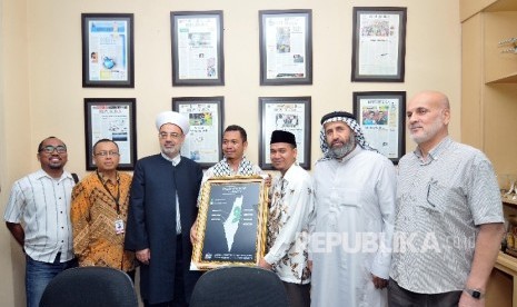 Redaktur Pelaksana Harian Republika Subroto (keempat kiri) menerima penghargaan dari General Secretary Indonesia National Commite for Palestinian People Suhartono Tjipto Basuki (ketiga kanan) didampingi perwakilan redaksi Harian Republika dan Majelis Ulama Palestina di Gedung Harian Republika, Jakarta, Senin (9/10).