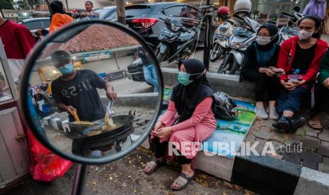 Refleksi dari cermin pedagang kaki lima melayani pembeli, Pemerintah meluncurkan program Bantuan Tunai untuk Pedagang Kaki Lima dan Warung (BTPKLW). (ilustrasi).