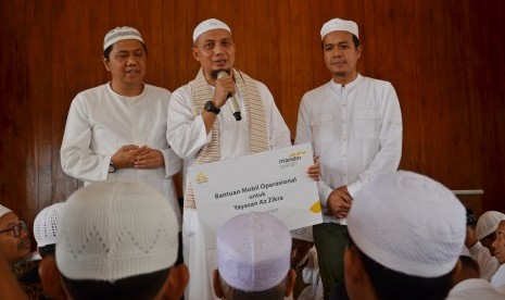 Region Head III Bank Syariah Mandiri Edhie Rosman (kanan) didampingi Branch Manager BSM KC Depok Dua Tamaruddin (kiri) secara simbolik menyerahkan bantuan kendaraan operasional kepada pendiri Yayasan Az-Zikra Ustadz Arifin Ilham (tengah) di Masjid Az-Zikra