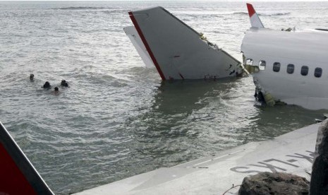 Regu penyelam berusaha mengambil perekam suara kokpit pesawat Lion Air keluar dari reruntuhan pesawat di dekat Bandara Internasional Ngurah Rai di Kuta, Bali, Senin (15/4).   (AP/ Firdia Lisnawati)