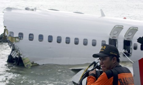 Regu penyelamat bersiap-siap untuk mengambil perekam suara kokpit pesawat Lion Air keluar dari reruntuhan pesawat di dekat Bandara Internasional Ngurah Rai di Kuta, Bali, Senin (15/4).   (AP/ Firdia Lisnawati)