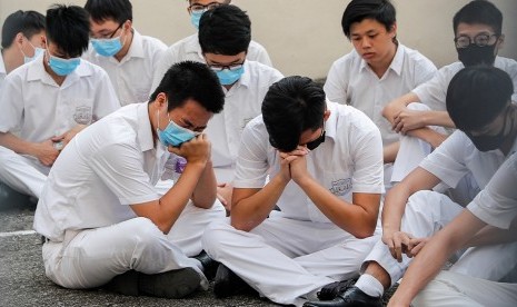 Rekan sekolah Tsang Chi-kin, pria yang ditembak polisi Hong Kong, melakukan aksi duduk di sekolah mereka, rabu (2/10). 