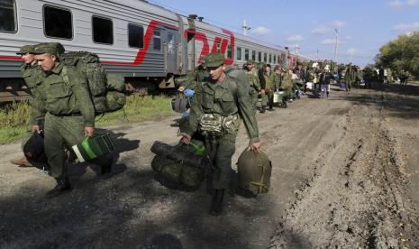 Rekrutmen Rusia berjalan untuk naik kereta api di stasiun kereta api di Prudboi, wilayah Volgograd Rusia, Kamis, 29 September 2022. Presiden Rusia Vladimir Putin telah memerintahkan mobilisasi sebagian pasukan cadangan untuk memperkuat pasukannya di Ukraina. Dengan mundurnya tentara Rusia di bawah pukulan pasukan Ukraina yang dipersenjatai dengan senjata Barat, Putin meningkatkan taruhannya dengan mencaplok empat wilayah Ukraina dan mendeklarasikan mobilisasi parsial hingga 300.000 pasukan cadangan untuk menopang garis depan yang runtuh.