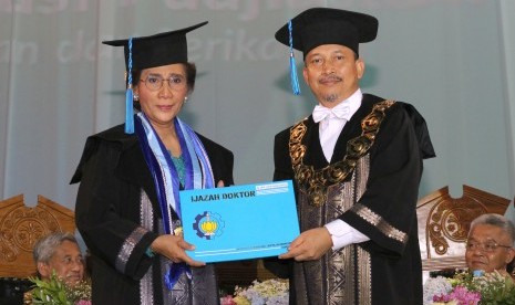 Rektor Institut Teknologi Sepuluh Nopember (ITS) Surabaya Joni Hermana (kanan) memberikan ijazah kepada Menteri Kelautan dan Perikanan Susi Pudjiastuti (kiri) saat penganugerahan gelar kehormatan di Institut Teknologi Sepuluh Nopember (ITS) Surabaya, Jawa Timur, Jumat (10/11).