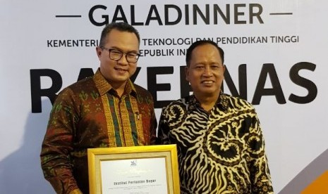 Rektor IPB Arif Satria (kiri) menerima penghargaan dari Menristekdikti M Nasir, berupa peringkat pertama PTNBH Terbaik dalam Pelaksanaan Program dan Anggaran, dan peringkat ketiga di bidang Publisititas.