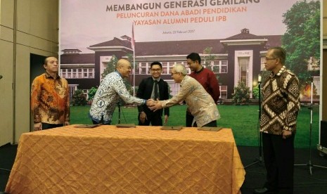 Rektor IPB Herry Suhardiyanto (kanan) dan Ketua Himpunan Alumni IPB Bambang Hendroyono (kiri)   menyaksikan kerja sama komitmen penyertaan Dana Abadi Pendidikan  dari PT Kustodian Sentral Efek Indonesia, Dana Pensiun PT Telkom, PT  Bursa Efek Indonesia dan PT Bahana TCW Investment.