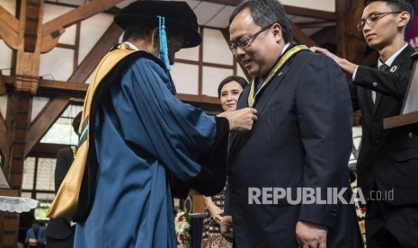 Rektor ITB Kadarsah Suryadi (kiri) menyematkan tanda penghargaan kepada Menteri Perencanaan Pembangunan Nasional (PPN)/Kepala Bappenas Bambang Brodjonegoro (kedua kiri) saat menerima penghargaan pada peringatan ke 98 Pendidikan Tinggi Teknik di Bandung, Jawa Barat, Rabu (4/7). 