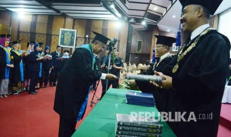 Rektor Unisba Prof Edi Setiadi memberikan Ijazah dan Tafsil Alquran kepada wisudawan pada Pelantikan Lulusan Program Doktor, Magister, Profesi dan Sarjana Unisba.