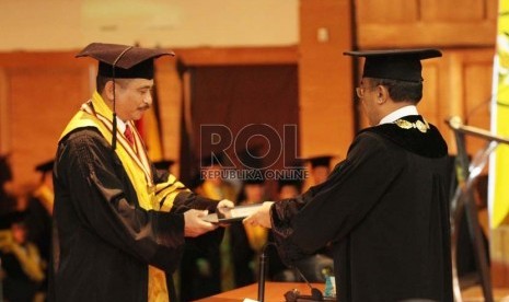 Rektor Universitas Padjadjaran (Unpad) Ganjar Kurnia mewisuda  Arief Yahya (kiri) pada Wisuda Unpad 2014 di Gedung Graha Sanusi Kampus Unpad, Jl Dipatiukur, Kota Bandung, Selasa (26/8) lalu.Republika/Edi Yusuf)