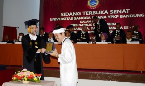 Rektor Universitas Sangga Buana (USB) Dr. H. Asep Effendi R. SE, MSi menyerahkan cenderamata pada Bupati Purwakarta Dedi Mulyadi usai Dedi memberikan Kuliah Terbuka pada Civitas Akademika USB pada Dies Natalis dan Wisuda USB di Kampus USB, Bandung, Sabtu (17/10). Foto: Sandy Ferdiana