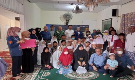 Rektor Unkris Ayub Muktiono (berbaju putih berdiri di belakang) berfoto bersama anak yatim.