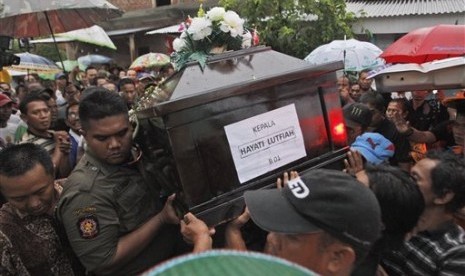 Relatives carry the coffin containing the body of Hayati Lutfiah hamid, one of the victims of AirAsia Flight 8501, during her burial at a cemetery in Surabaya, East Java, Indonesia, Thursday, Jan. 1, 2015. 