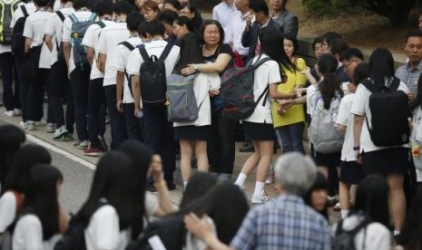 Relatives of the April 16 ferry disaster victims comfort students who survived the accident as they make their way back to school in Ansan June 25, 2014.