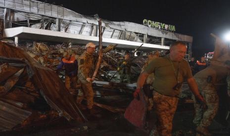 Relawan bekerja untuk mengambil puing-puing di pusat perbelanjaan yang terbakar setelah serangan roket di Kremenchuk, Ukraina, Selasa pagi, 28 Juni 2022.