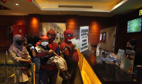 Relawan berkostum tokoh animasi spiderman mengajak anak yatim untuk menonton film di bioskop salah satu pusat perbelanjaan di Solo Baru, Sukoharjo, Jawa Tengah, Kamis (23/12/2021). Aksi tersebut digelar sebagai trauma healing untuk menghibur anak yatim yang orang tuanya meninggal akibat COVID-19.