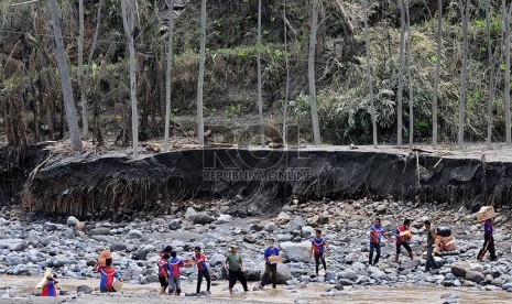 Relawan berusaha mengirimkan bantuan melalui sungai yang terputus akses jalannya akibat lahar dingin Gunung Kelud yang terputus akses jalannya akibat lahar dingin Gunung Kelud di Dusun Klangon, Malang, Jawa Timur, Kamis (20/2).