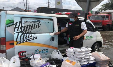 Relawan BMH bersiap membagikan nasi bungkus kepada warga korban banjir di Semarang, Jawa Tengah, Jumat (12/2).