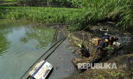 Relawan dan petugas damkar menangani tumpahan oli yang bocor dari pabrik tekstil dan mencemari waduk Saguling, Desa Laksanamekar, Kecamatan Padalarang, Kabupaten Bandung Barat, Selasa (4/4). 