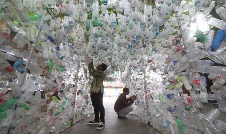 Relawan dari Ecological Observation and Wetlands Conservation (Ecoton) merapikan karya instalasi sampah botol plastik saat Festival Kali Brantas di Kota Kediri, Jawa Timur, Sabtu (29/10/2022). Kegiatan berbagi bibit pohon dan pameran instalasi sampah botol plastik tersebut sebagai upaya mengkampanyekan kelestarian sungai Brantas. 