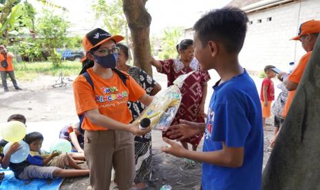 Relawan dari Kawan Lama Group (kiri memakai kaos oranye) memberikan hadiah kepada pemenang permainan dalam rangkaian kegiatan trauma healing. Kawan Lama Group melalui Kawan Lama Foundation menyalurkan bantuan untuk masyarakat terdampak erupsi Gunung Semeru di Kecamatan Candipuro, Kabupaten Lumajang, Jawa Timur.