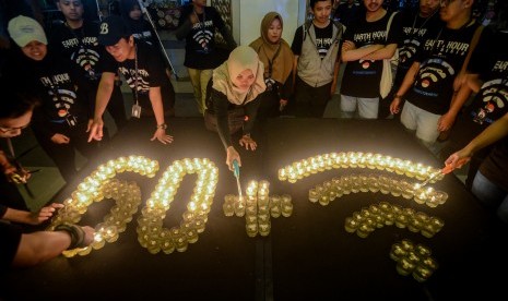 Relawan dari World Wide Fund for Nature (WWF) Indonesia menyalakan lilin saat perayaan Earth Hour di Bandung, Jawa Barat, Sabtu (30/3/2019). Tahun ini Earth Hour digelar virtual.