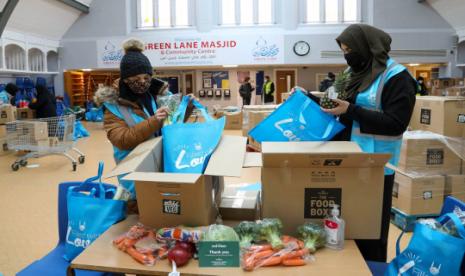 Relawan di Green Lane Masjid di Birmingham, Inggris mengepak makanan untuk dibagikan pada mereka yang membutuhkan, 30 Januari 2021.