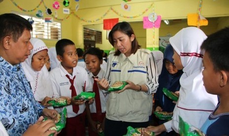 Relawan GarudaFood Sehati dan Zaenal. S.Pd Guru kesiswaan SDN Ciputat 01 memberikan pemahaman  mengenai cara membaca label pada kemasan produk GarudaFood kepada ratusan siswa-siswi SDN Ciputat 01 Tangerang Selatan yang mengikuti kegiatan sharing sessionmengenai Keamanan Pangan (Food Safety) di SDN 01 Ciputat 01 Tangerang Selatan (2/5). 