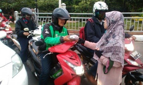 Relawan KNRP membagikan takjil on the road di TB Simatupang.