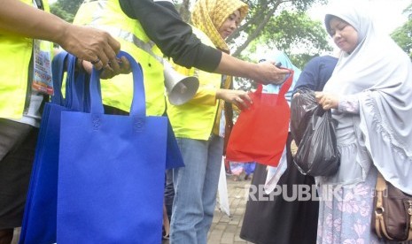 Relawan Konsorsium Peduli Bogor (KPB) membagikan tas guna ulang saat sosialisasi Bogor Anti Kantong Plastik (Antik) di Taman Ekspresi, Kota Bogor, Jawa Barat, Ahad (25/11). 