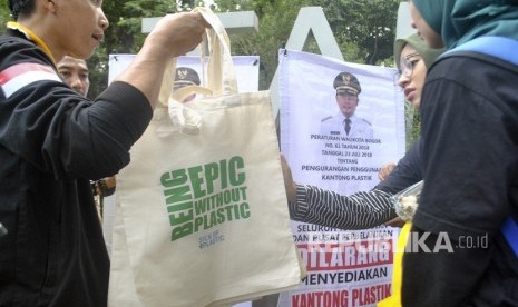 Relawan Konsorsium Peduli Bogor (KPB) membagikan tas guna ulang saat sosialisasi Bogor Anti Kantong Plastik (Antik) di Taman Ekspresi, Kota Bogor, Jawa Barat, Ahad (25/11). 