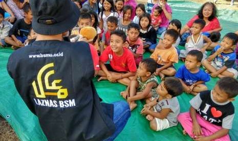 Relawan Laznas BSM memberikan MPASI untuk balita di pengungsian Lombok.