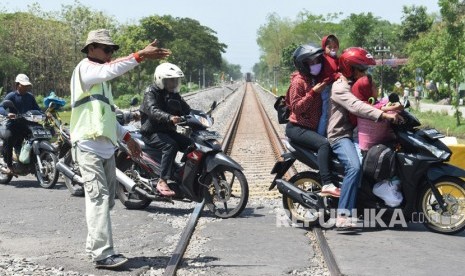 Relawan memandu pengendara di perlintasan Kereta Api (KA) tanpa palang pintu.