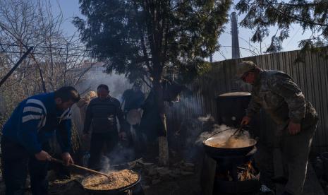 Relawan memasak di halaman sebuah teater di kota Drohobych, Ukraina barat, Senin (21/3/2022). Teater tersebut menjadi titik pertemuan, di mana para seniman, termasuk mereka yang mengungsi dari bagian lain Ukraina, menyalurkan bakat mereka untuk membuat makanan untuk tentara dan lainnya sebagai bagian dari upaya perang sukarela besar-besaran di seluruh negeri.