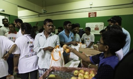 Relawan membagikan hidangan berbuka untuk buruh di Dubai.